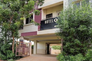 A two-story building with a sign that reads 'HOTEL' above the entrance. - Hotel O Enikepadu (Penumuluru)