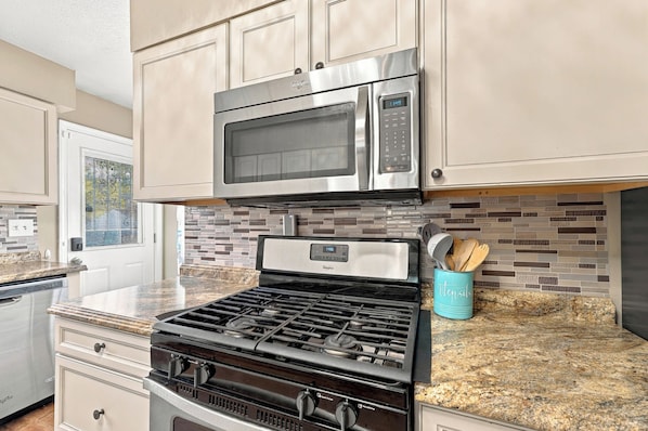 A kitchen with stainless steel appliances, a tiled backsplash, and a granite countertop. - Spacious home near Bourbon Trail & Churchill Downs (Louisville)