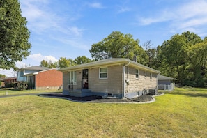 A single-story house with a front porch, a brick garage, and a well-maintained lawn. - Spacious home near Bourbon Trail & Churchill Downs (Louisville)