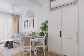 A modern living room with a dining area, white furniture, and a large white wardrobe. - Bright Studio with Balcony in City Centre by Noclegi Renters (Warszawa)