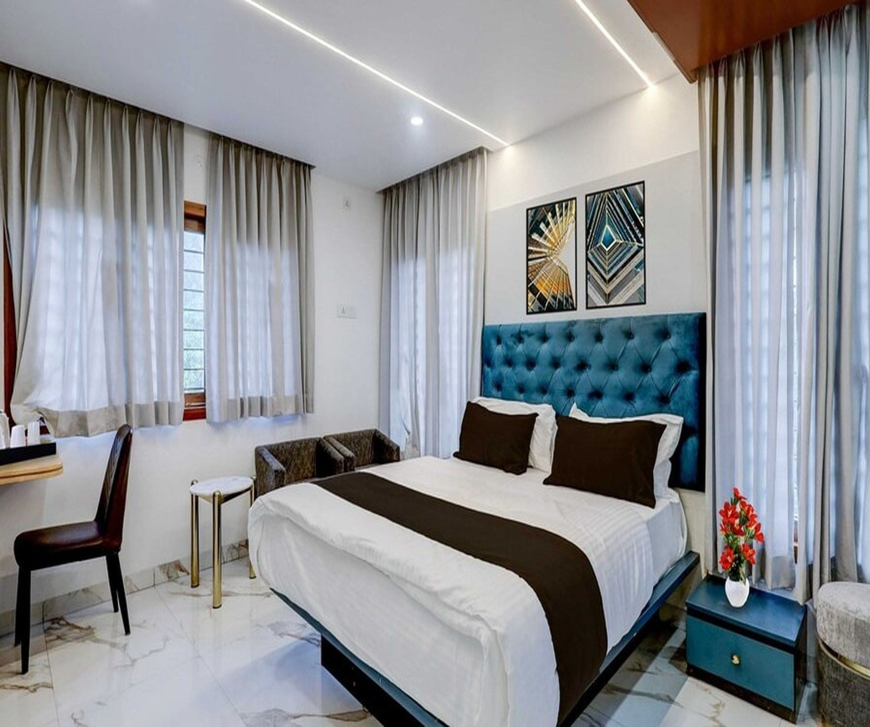 A modern hotel room with a large bed, a desk, and a chair.