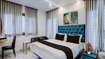 A modern hotel room with a large bed, a desk, and a chair.