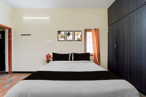 A hotel room with a bed, a wardrobe, a window with curtains, and three framed artworks on the wall. - Hotel O Madurai City Centre (Madurai)