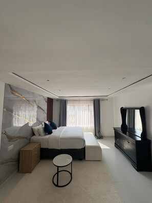 A modern bedroom with a bed, bedside table, and a dresser. - 2-bedroom cottage in Bulawayo (Bulawayo)