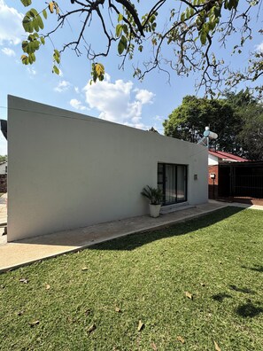 A modern building with a flat roof, a small potted plant, and a clear sky. - 2-bedroom cottage in Bulawayo (Bulawayo)