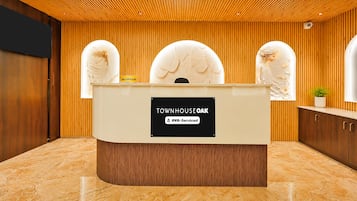 Un mostrador de recepción con un cartel que indica 'Townhouse Oak' y 'OYO-Serviced'.