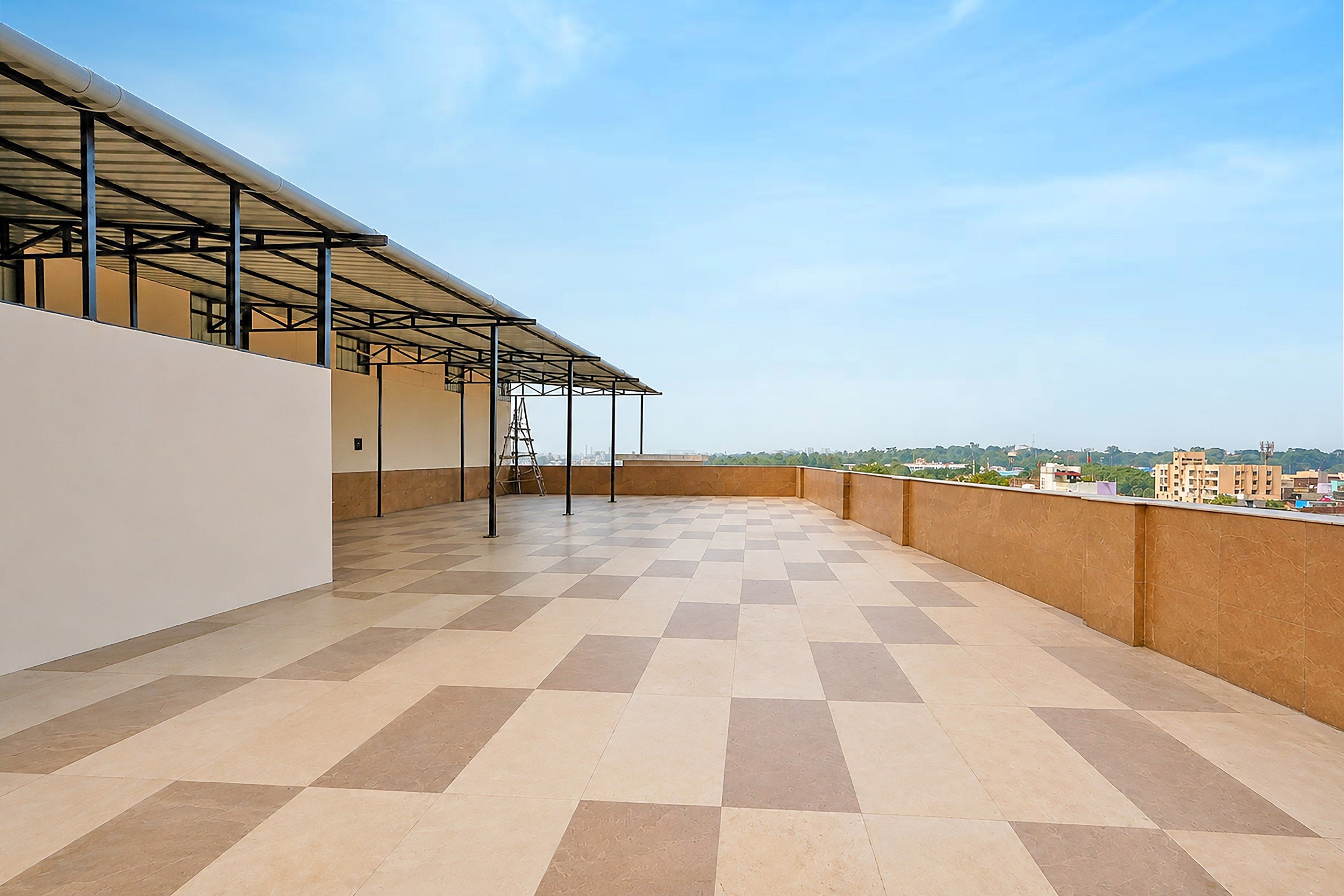 A rooftop terrace with a checkered floor, metal roof structure, and a view of the cityscape.
