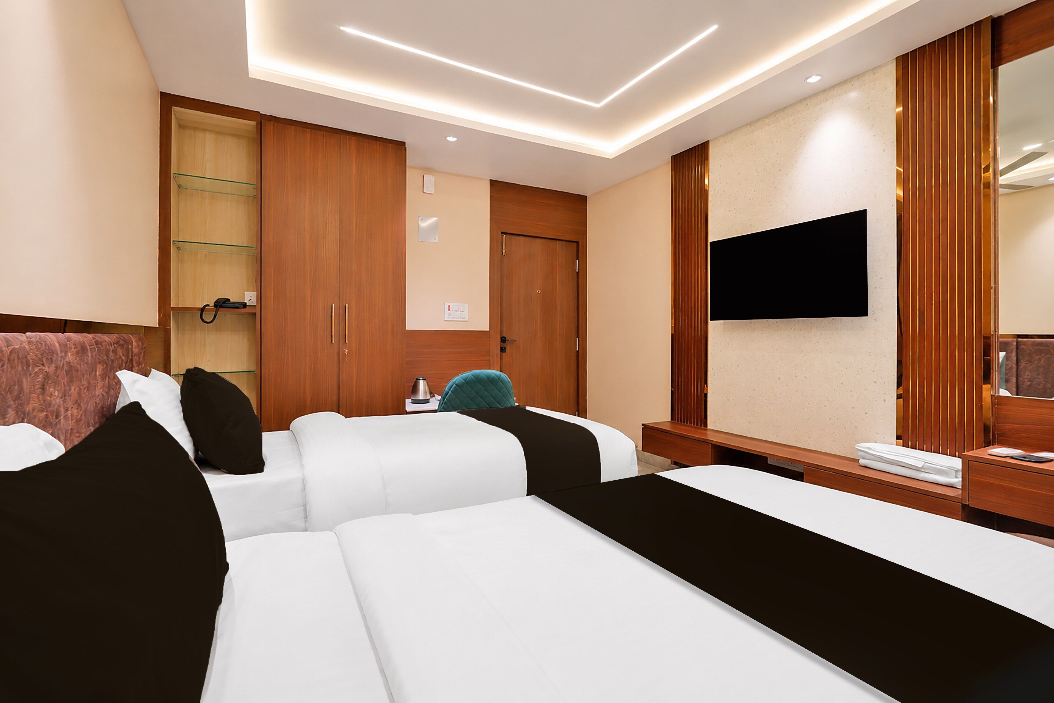 Una habitación de hotel con cama, escritorio, televisor y armario.