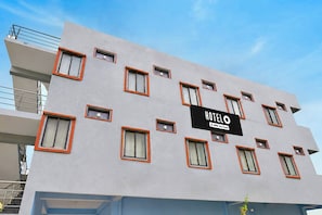 Un edificio de hotel con varias ventanas y un cartel que indica que es atendido por una empresa específica.