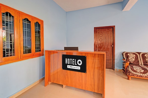 Una recepción de hotel con un cartel que indica que es atendida por Oyo.