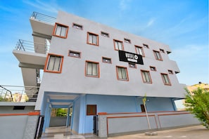 Edifici d'hotel modern amb un senyal que indica que ofereix serveis OYO.