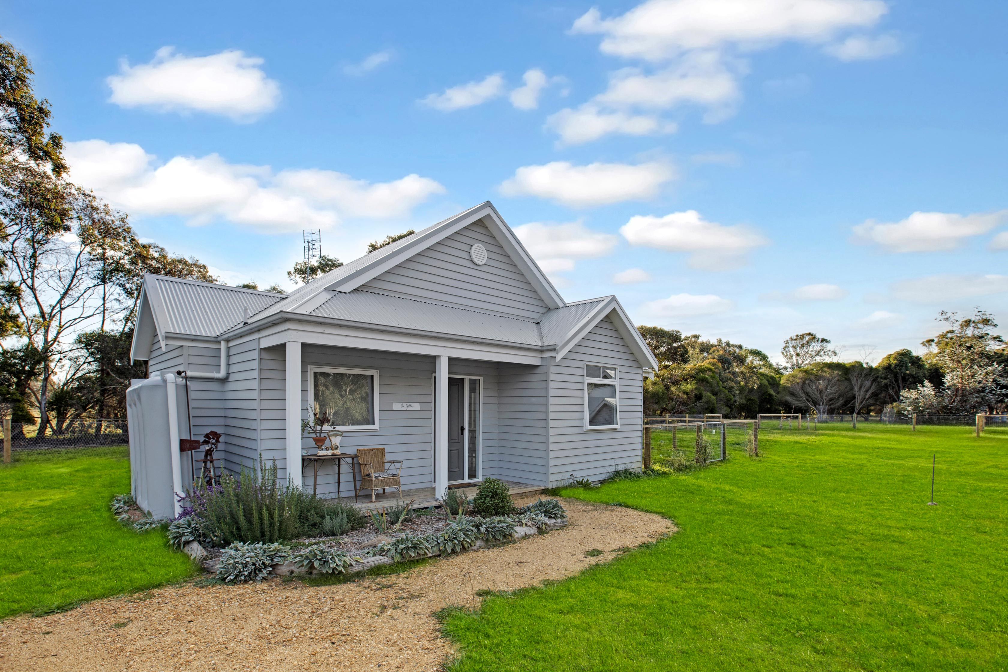 Einbungalow mit Veranda, kleinem Garten und umzäunter Grundstück.