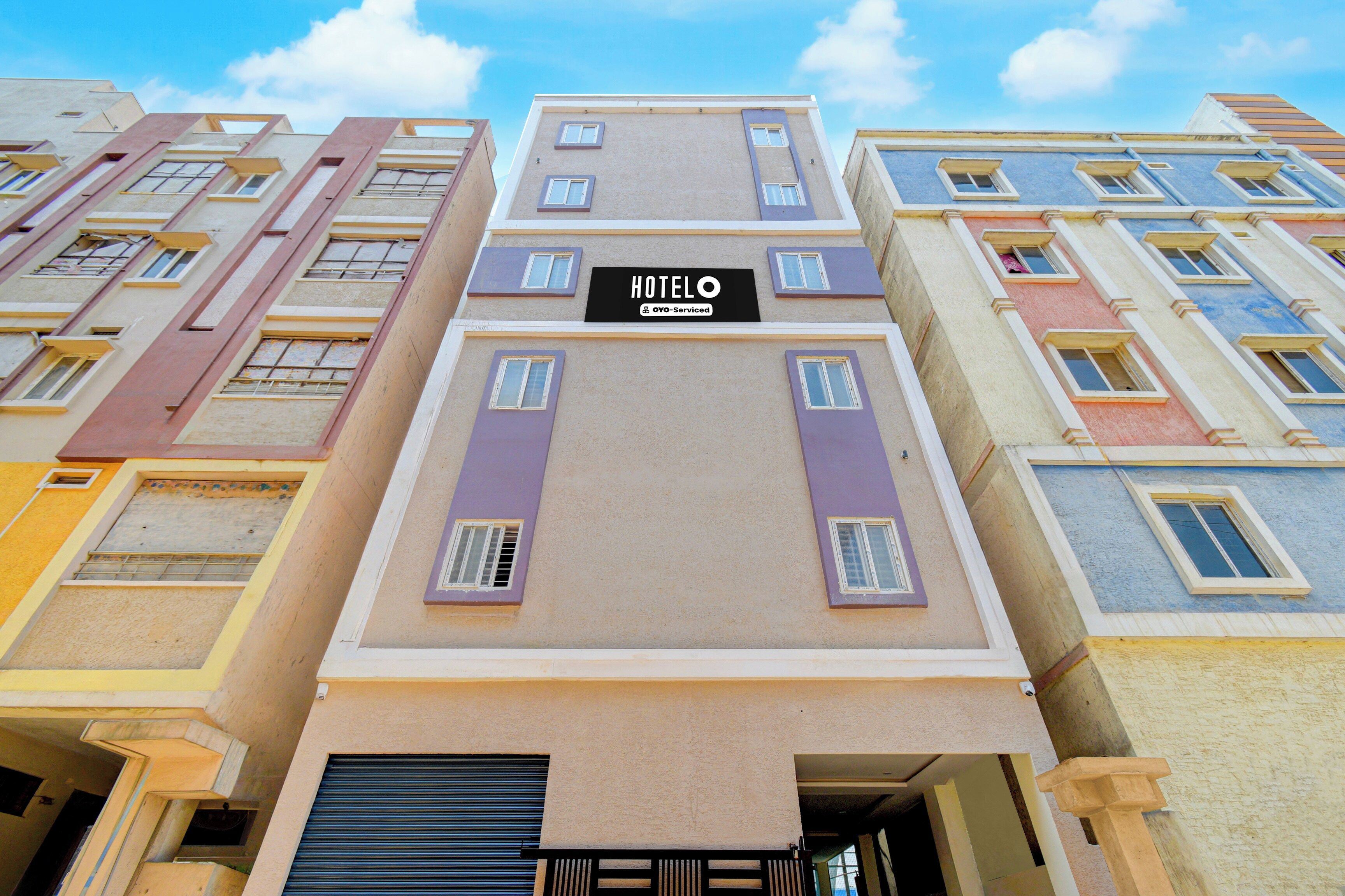 Un edificio de hotel de varios pisos con un letrero que dice 'HOTEL' y 'ovo-serviced', indicando la disponibilidad de servicios en el lugar.