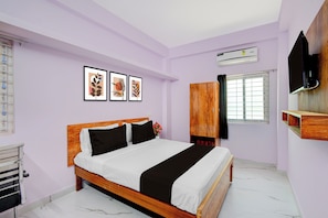 A bedroom with a bed, a wardrobe, a TV, and framed artwork on the wall. - Hotel O Gandimaisamma Temple Hyderabad (Hyderabad)