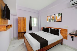 A bedroom with a bed, a TV, a wardrobe, a window with curtains, and artwork on the wall. - Hotel O Gandimaisamma Temple Hyderabad (Hyderabad)