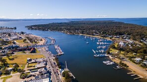 An aerial view of a marina with multiple docks, boats, and surrounding residential areas. - Kingfisher:  All about relaxed Raymond Island living (Raymond Island)