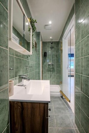 A modern bathroom with a sink, mirror, and shower. - Berwick Soho Suites by Aureva Residences (London)