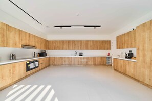 Eine moderne Küche mit Holzausstattung, einer weißen Arbeitsplatte und eingebauten Geräten.