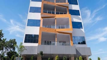 A multi-story building with a modern architectural design, featuring a combination of glass and brick facade, and a flat roof.