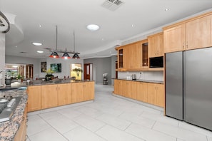 A modern kitchen with wooden cabinets, stainless steel appliances, and a granite countertop. - Luxurious 4-bedroom Villa With Private Pool in Hartbeespoort (Hartbeespoort)