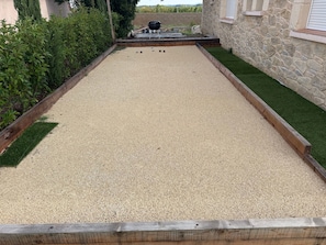 Una cancha de croquet con un muro de piedra y un borde cubierto de césped.