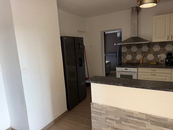 A kitchen with a built-in oven, a refrigerator, and a microwave.