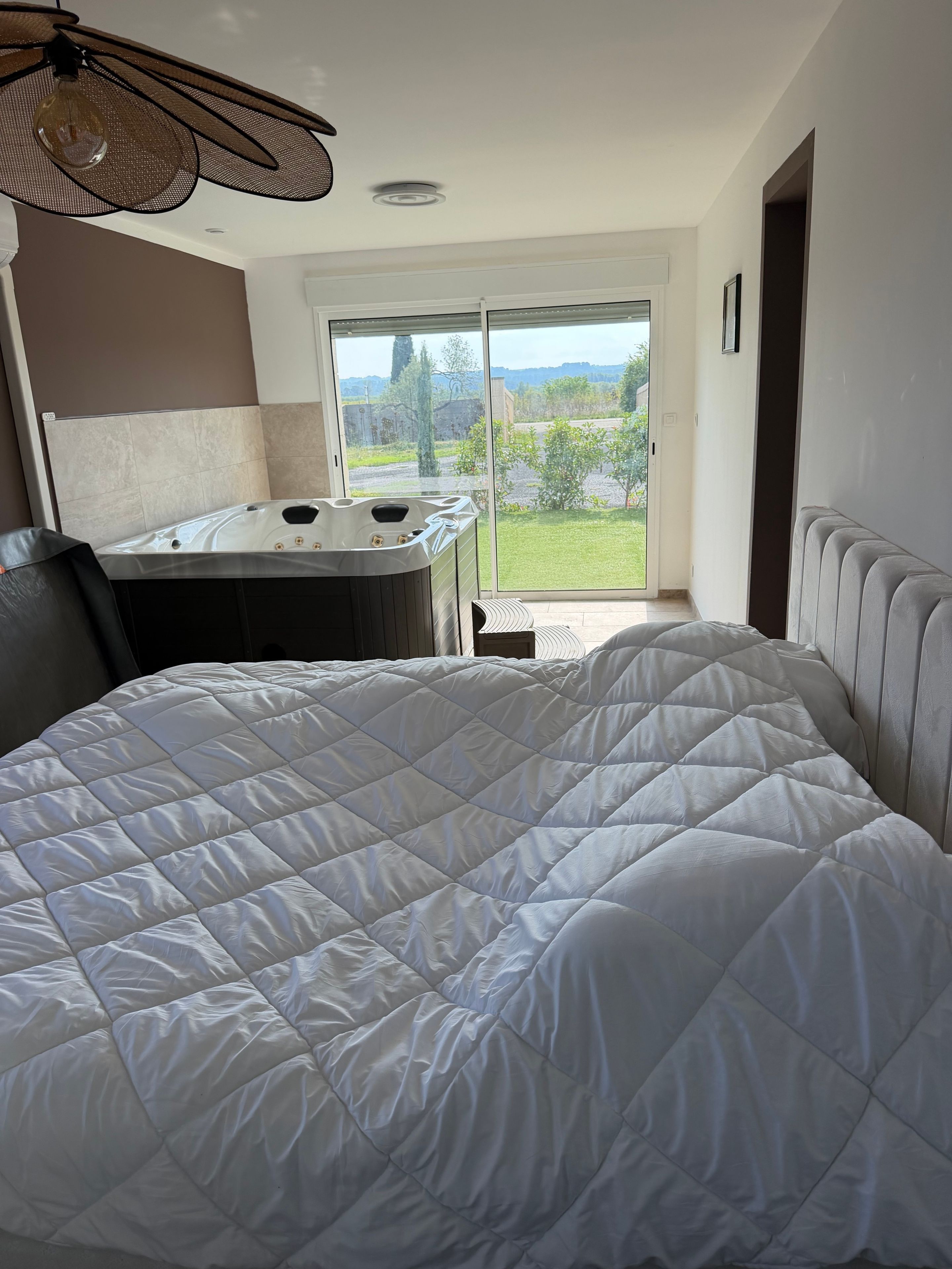 Quarto com cama grande, hidromassagem e vista para o exterior.
