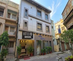 Ein Hotel mit einer Rezeption, einem Schild, das es als G. Crieasing Residence kennzeichnet, und Pflanzen im Topf vor der Fassade.