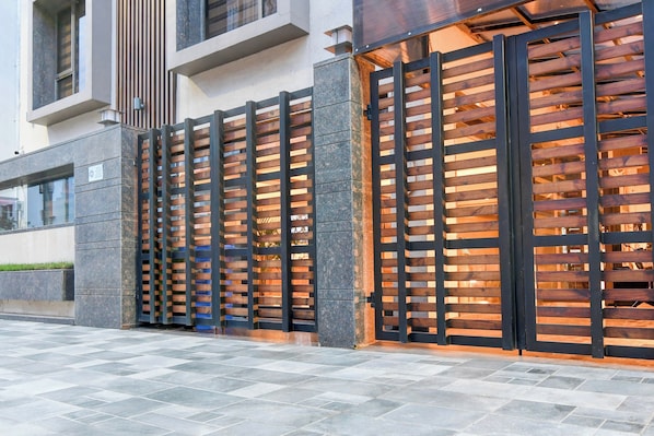 A modern building facade with a series of vertical wooden slats and black metal frames. - Townhouse Oak DLF Newtown Bus Terminal (Barasat)