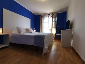 A bedroom with a bed, bedside table, and a television. - Hotel Trasgu (Cangas de Onís)