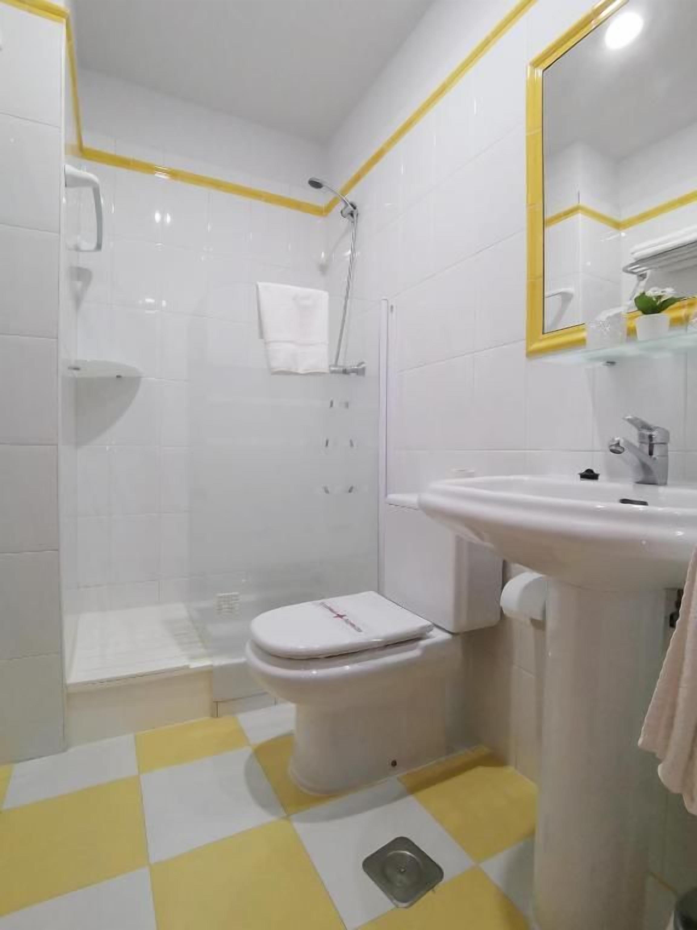 Een badkamer met toilet, wastafel en douche.