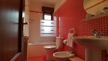 A bathroom with a toilet, bidet, and sink.