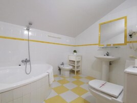 Casa de banho com banheira, sanita, bidé e lavatório.