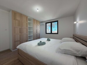A bedroom with a bed, a wardrobe, and a window with a view. - Spacious Air-Conditioned Villa, 5 Minutes from the Beach (Valras-Plage)
