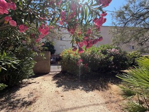 A garden pathway leading to a building with a gated entrance. - Spacious Air-Conditioned Villa, 5 Minutes from the Beach (Valras-Plage)
