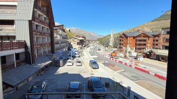 Una vista di strada con edifici, auto parcheggiate e cielo sereno.