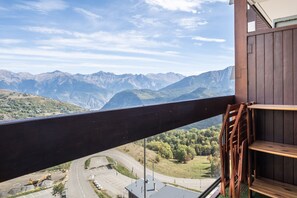 A balcony with a view of a mountainous landscape and a road with construction equipment. - Le Perchoir du Bonheur - Balcon avec vue montagne (Villarembert)