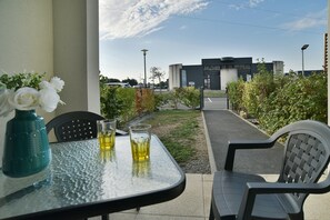 An outdoor seating area with a table, chairs, and a vase of white flowers. - L'Instant Émeraude - One Bedroom Apartment, Sleeps 2 (Dinard)