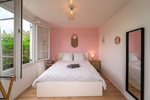 A bedroom with a bed, bedside table, lamp, and a large mirror. - La Maison entre 2 Caps - 2km de Fréhel (Plurien)