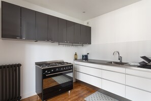 Een moderne keuken met een gasfornuis, oven en een roestvrijstalen spoelbak.