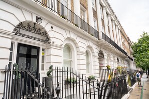 A traditional building with a white facade, black iron railings, and a sign indicating 'SMART HOSTELS'. - The Russel Square Apartmens (London)
