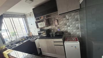 Een moderne keuken met een gasfornuis, een magnetron, een broodrooster en een koelkast.