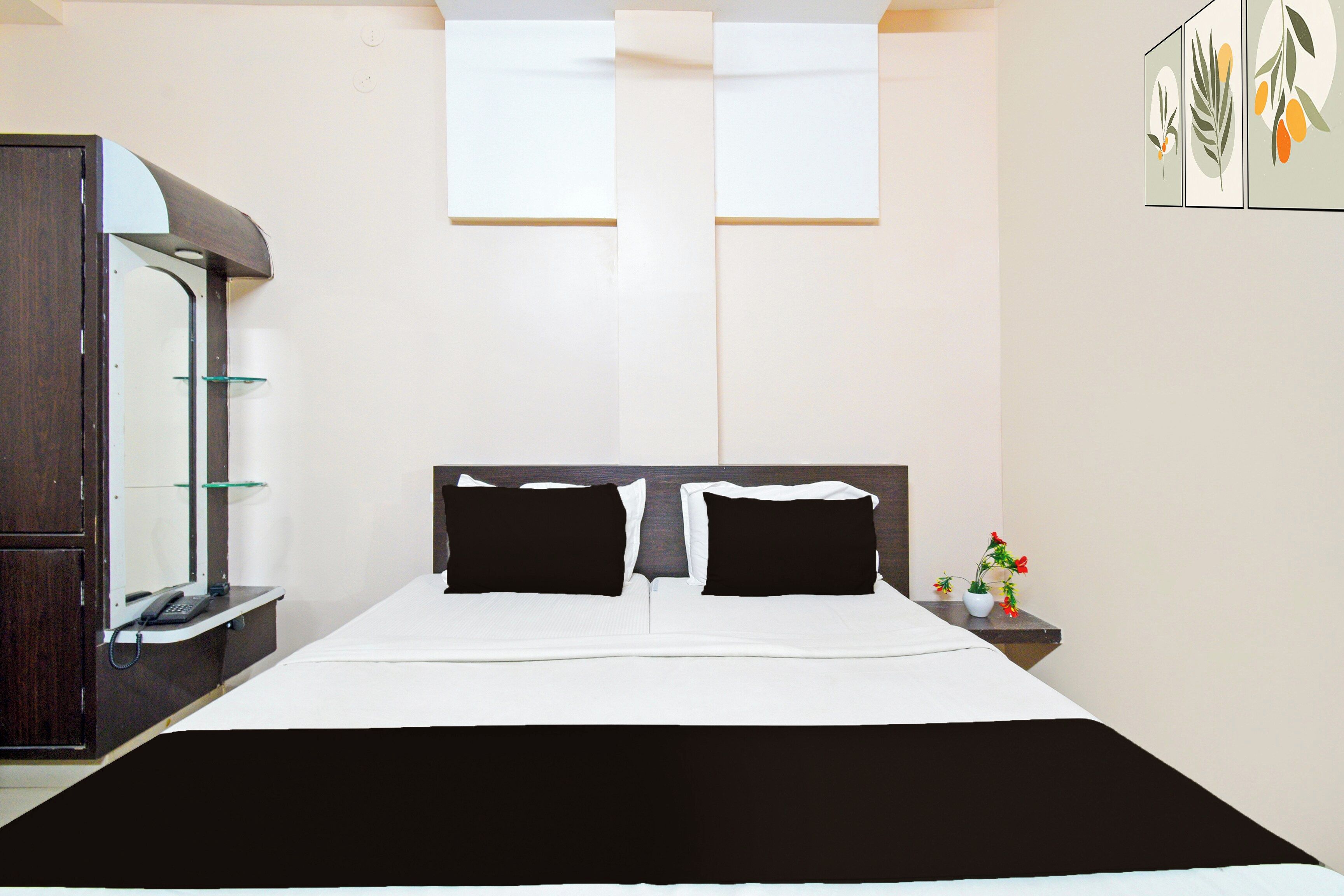 Una habitación de hotel con una cama, una mesita de noche, un espejo y una ventana.