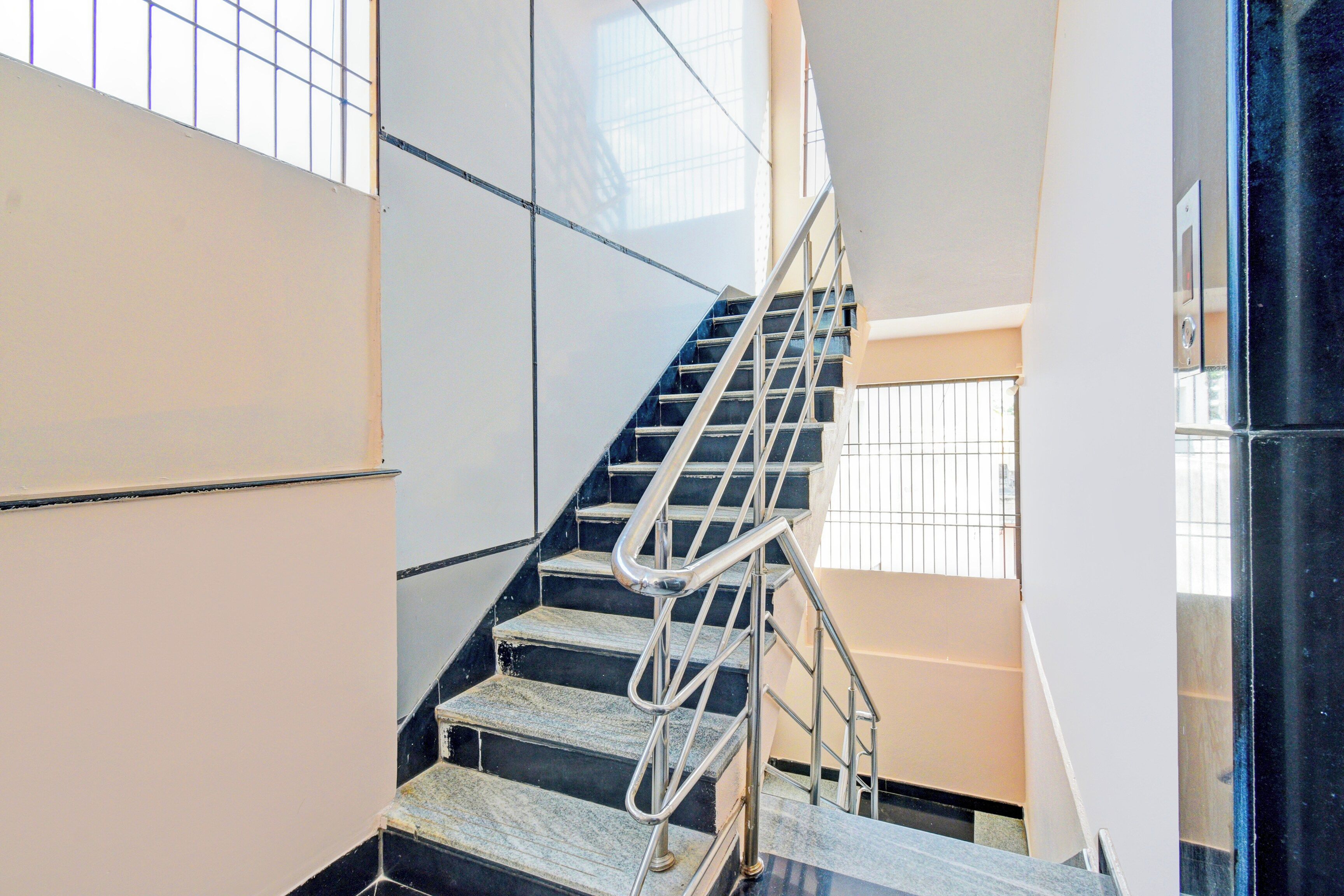 A staircase with metal railings and a handrail, leading to an upper floor.