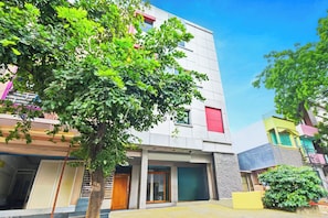 A modern building with a flat facade, multiple windows, and a visible entrance.