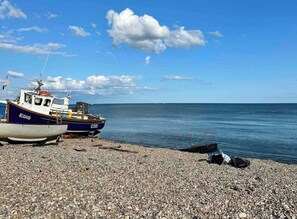 Ein Boot mit dem Kennzeichen E515 an einem Kiesstrand.