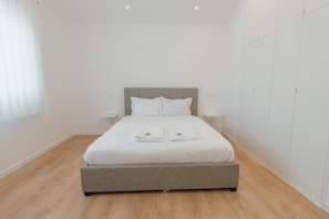 A bedroom with a bed, bedside tables, and a wardrobe. - Modern Lapa Duplex D by Vacationy (Porto)