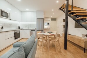 A modern kitchen with white cabinets, a built-in oven, and a microwave. - Modern Lapa Duplex D by Vacationy (Porto)