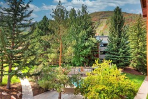 Un hôtel doté d’une piscine, entouré d’une forêt dense et situé dans un paysage vallonné.