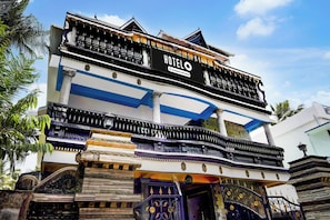 Un hotel con un cartel llamativo, varios balcones y elementos arquitectónicos tradicionales.